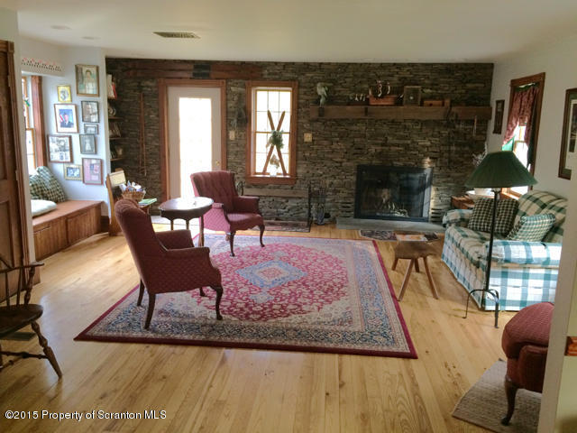 515 High Bridge Road Nicholson, PA 18446 - Photo 10 of 26 a living room with furniture a fireplace and a large window
