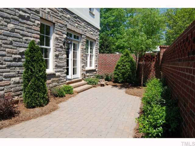 2603 Graves Court Raleigh, NC 27608 - Photo 4 of 4 Exquisitely landscaped grounds and patio with brick fencing for privacy