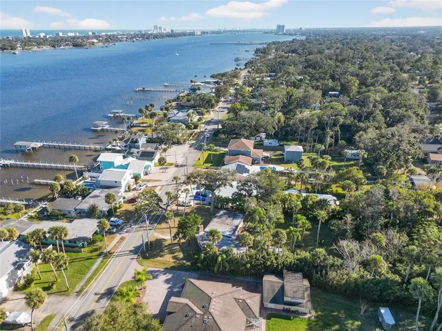 an aerial view of a city with lots of residential buildings ocean and mountain view in back