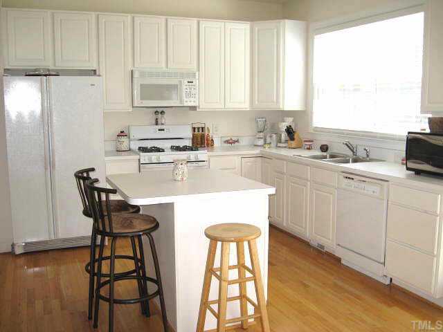 5444 Vista View Court Raleigh, NC 27612 - Photo 5 of 12 Large kitchen with gas range, pantry, island, & white cabinets/appliances