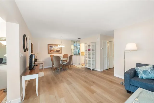 a living room with furniture a fireplace and a dining table with wooden floor