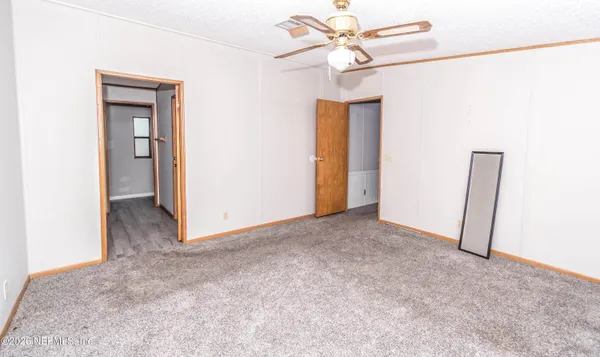 a view of a big room with closet and a chandelier fan