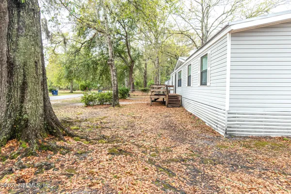 a view of a yard with a house and a tree