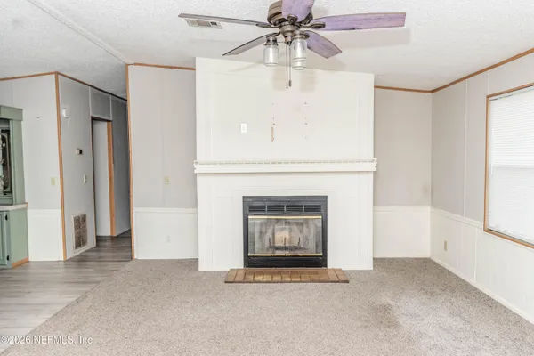 an empty room with windows and fireplace