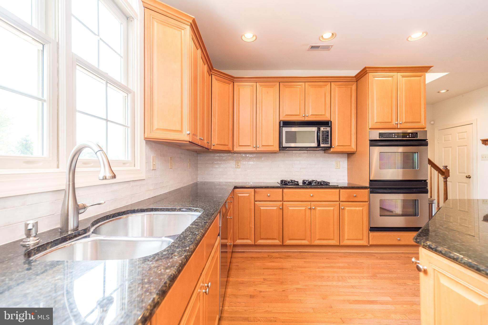 2517 Lockleigh Road Jamison, PA 18929 - Photo 28 of 72 a kitchen with stainless steel appliances granite countertop a sink a stove and a microwave oven with granite countertops