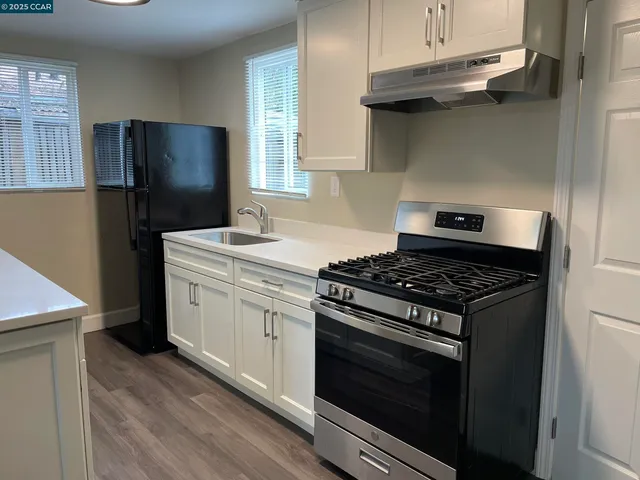 a kitchen with stainless steel appliances granite countertop a stove a refrigerator and a sink