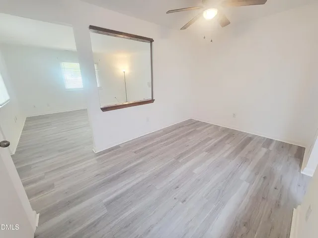 an empty room with wooden floor and mirror