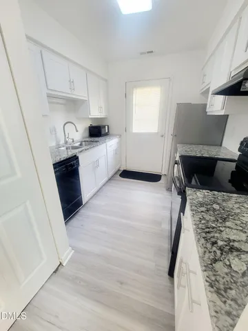 a kitchen with a refrigerator and a stove