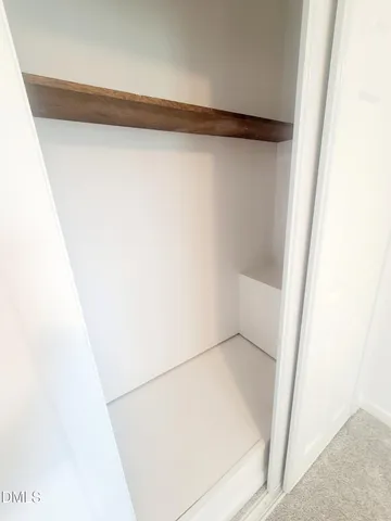 an empty room with a ceiling fan and window