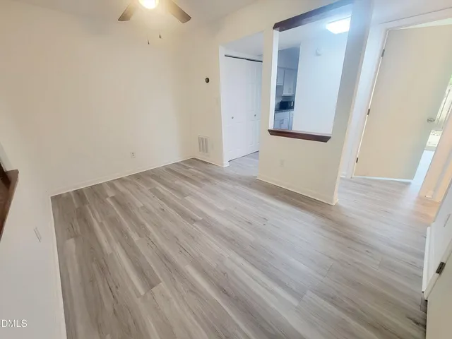 an empty room with wooden floor and a bathroom