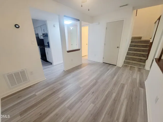 a view of a hallway with wooden floor and stairs