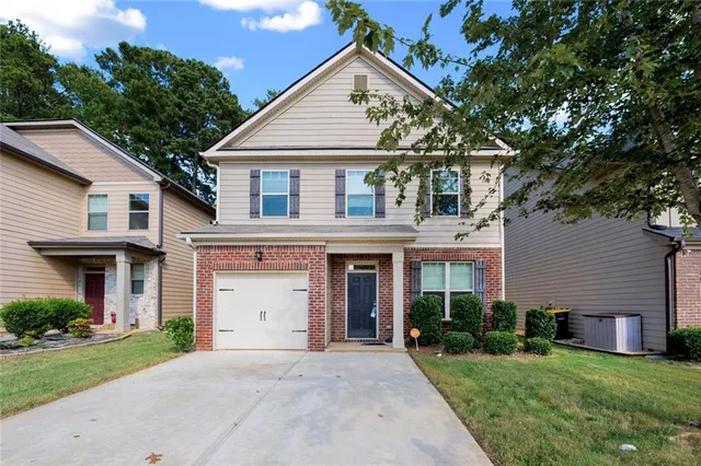 a front view of a house with a garden and plants