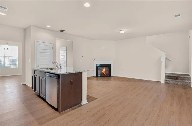 a kitchen with granite countertop stainless steel appliances a stove microwave and sink