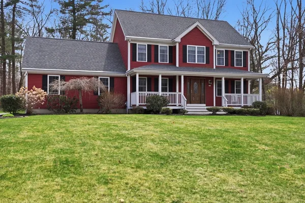 a front view of a house with a yard and trees