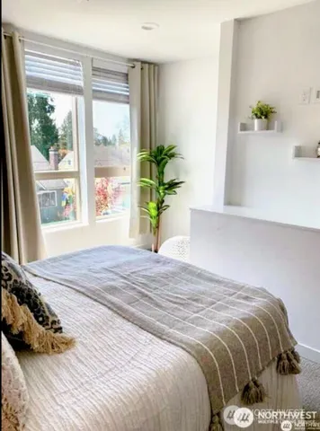 a bedroom with a bed and a potted plant