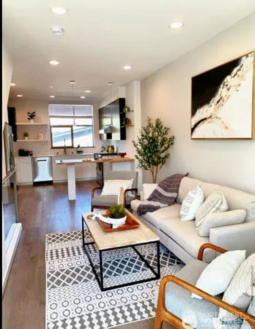 a living room with furniture and a wooden floor