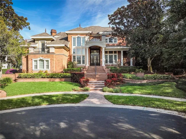 a front view of a house with a garden and trees