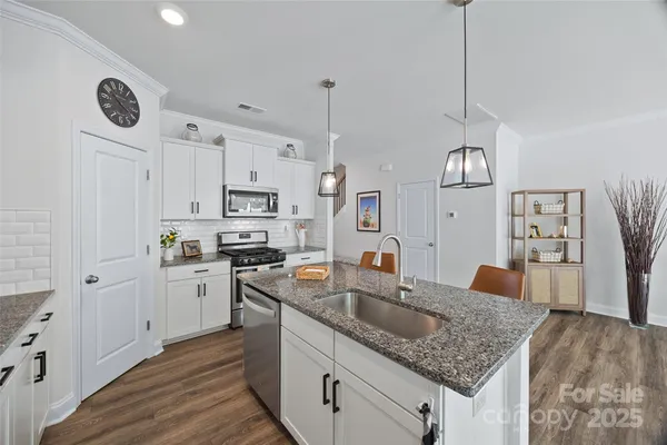 a kitchen with stainless steel appliances granite countertop a sink stove and refrigerator