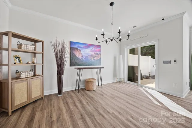 a view of a livingroom with wooden floor and a kitchen space