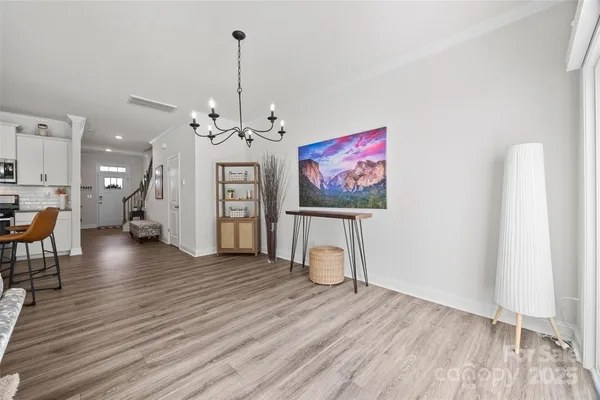 a view of a livingroom with wooden floor and a chandelier
