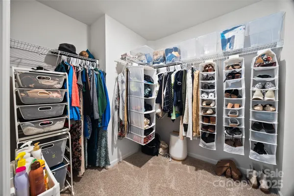 a view of walk in closet with clothes and shoes