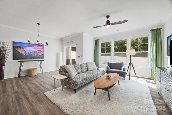 a living room with furniture a flat screen tv and a large window