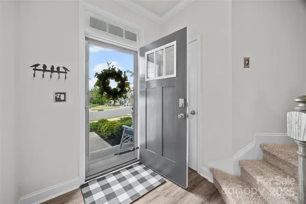 a view of a hallway with wooden floor and a livingroom