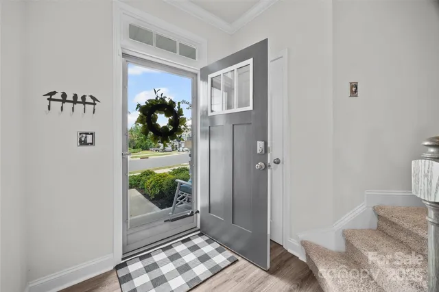 a view of a hallway with wooden floor and a livingroom
