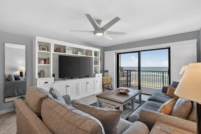 a living room with furniture a flat screen tv and a large window