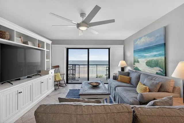 a living room with furniture a flat screen tv and a large window