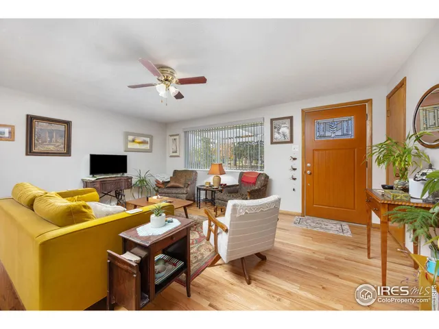 a living room with furniture a flat screen tv and a table