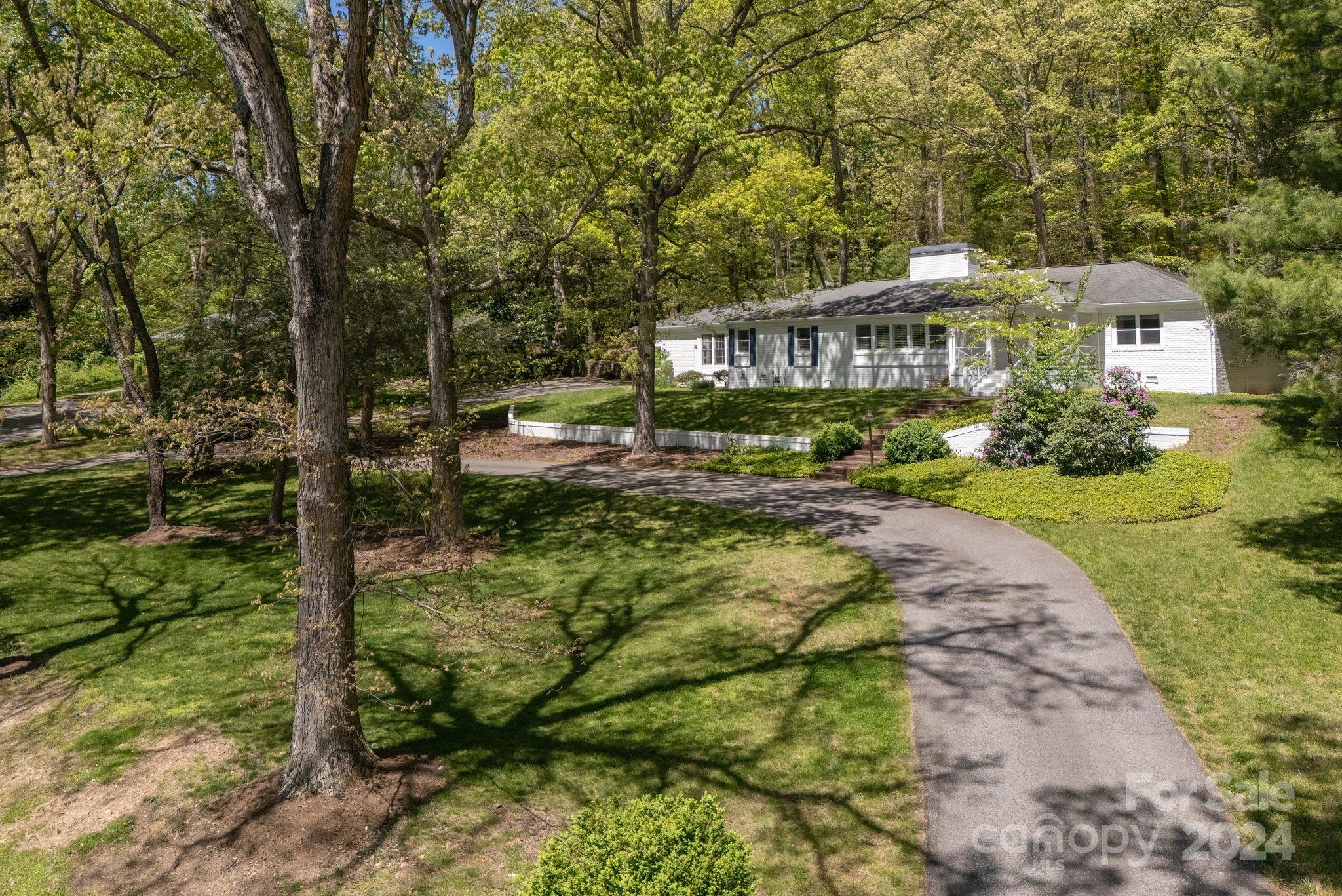 51 Forest Road Asheville, NC 28803 - Photo 1 of 45 a view of a big house with large trees and plants