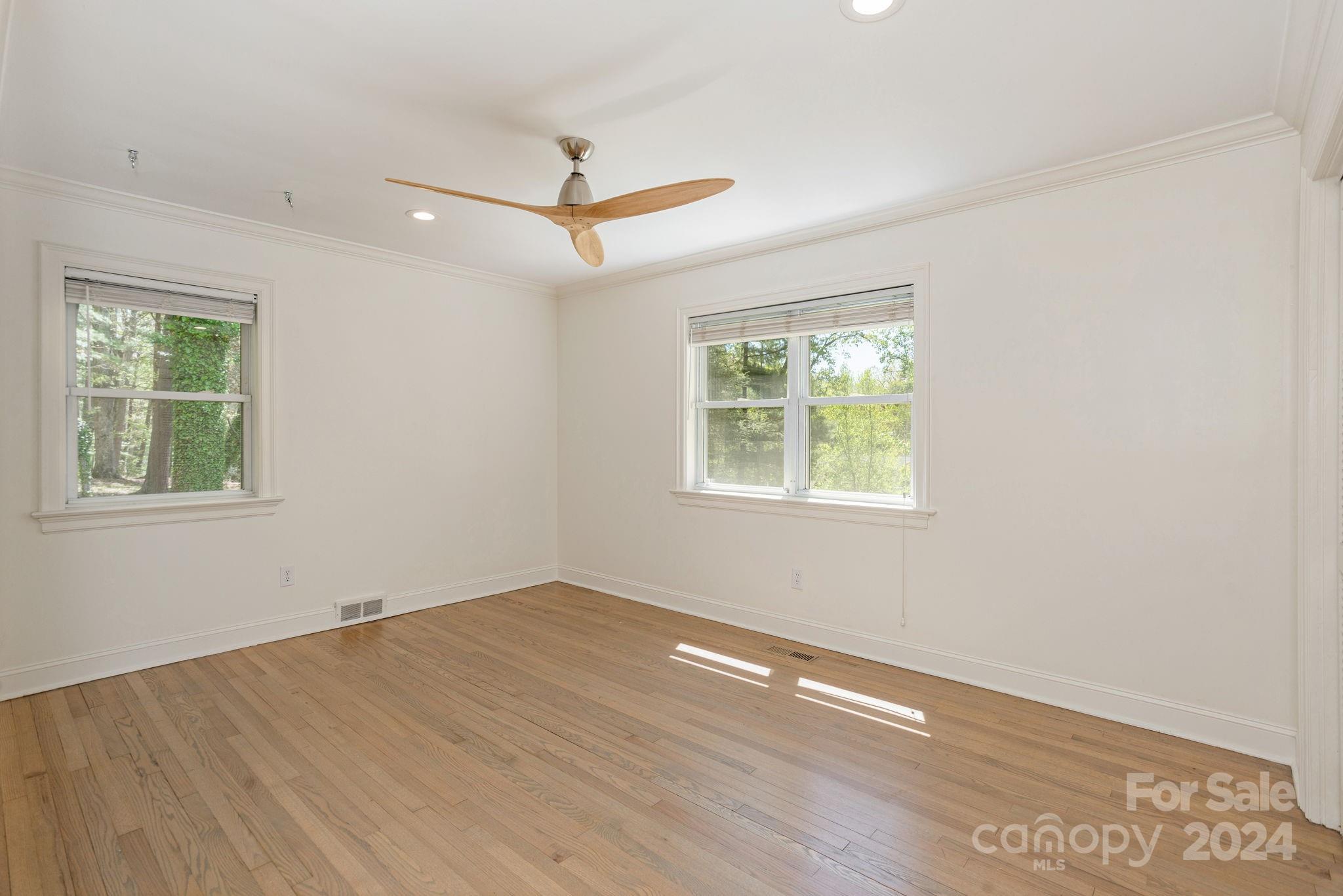 51 Forest Road Asheville, NC 28803 - Photo 32 of 45 an empty room with wooden floor ceiling fan and windows