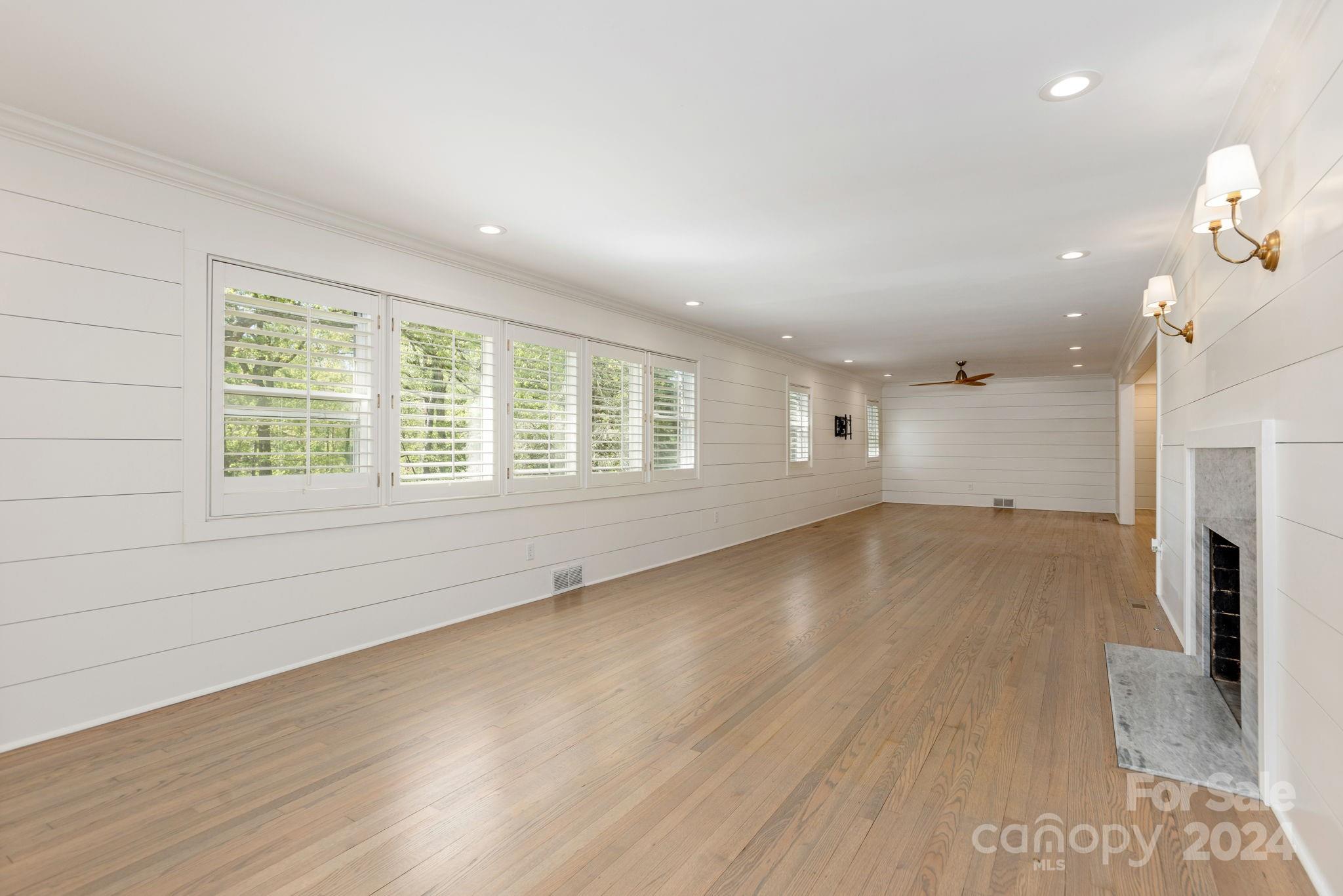 51 Forest Road Asheville, NC 28803 - Photo 7 of 45 an empty room with a fireplace and wooden floor