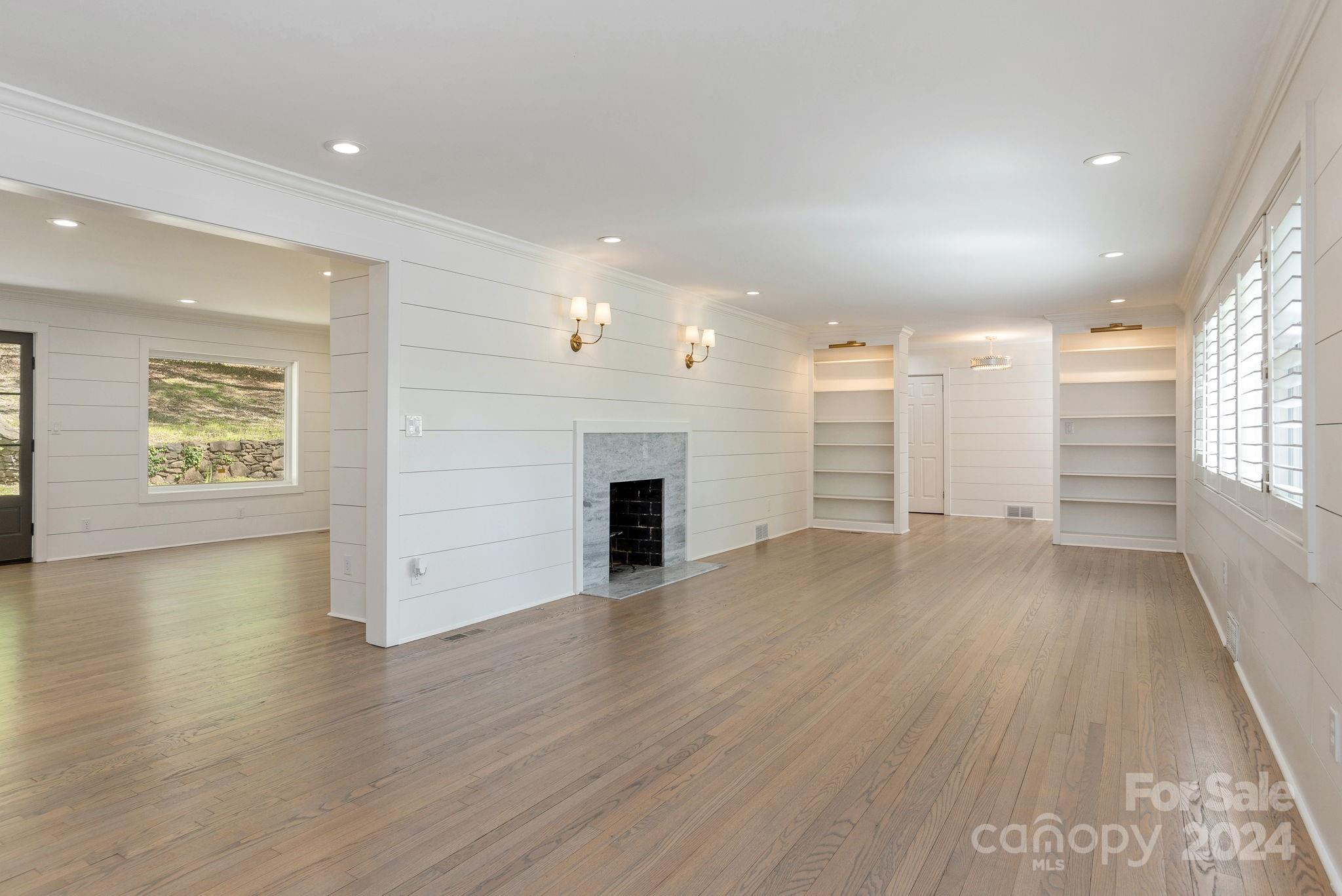 51 Forest Road Asheville, NC 28803 - Photo 9 of 45 an empty room with wooden floor fireplace and windows