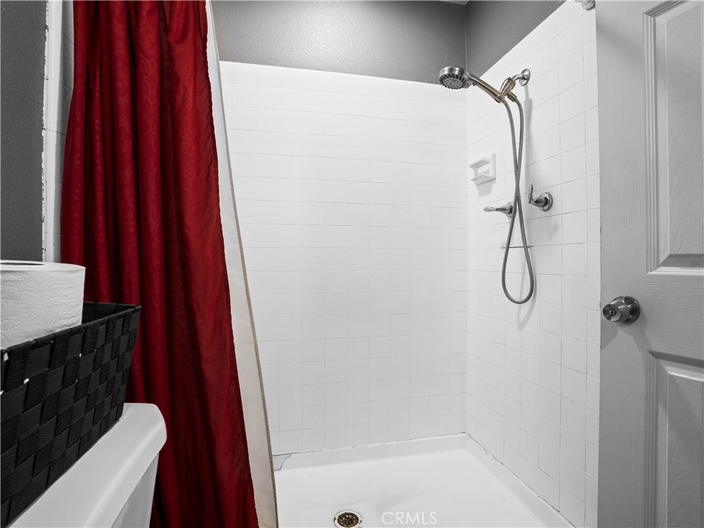 1455 North Alice Avenue Rialto, CA 92376 - Photo 21 of 23 a bathroom with a shower curtain and a sink with wooden floor
