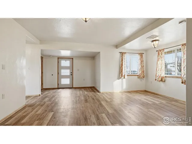 a open hall with wooden floor and windows