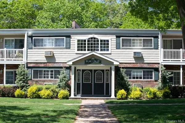 a front view of a house with a yard and potted plants
