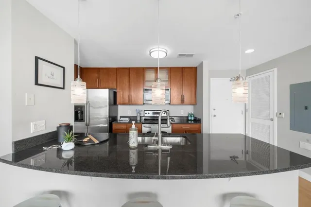 a kitchen with refrigerator and a view of living room