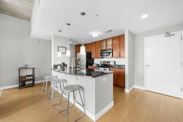 a kitchen with a sink a counter top space and stainless steel appliances