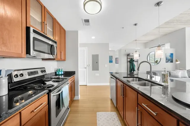 a kitchen with stainless steel appliances granite countertop a sink stove and cabinets