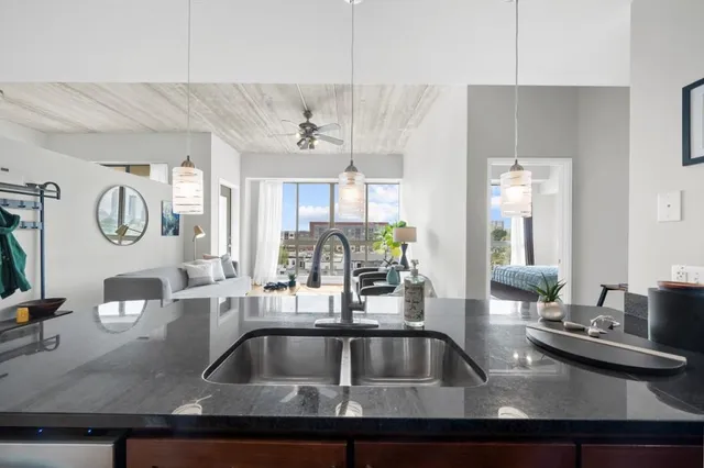 a kitchen with a sink and a stove with wooden floor