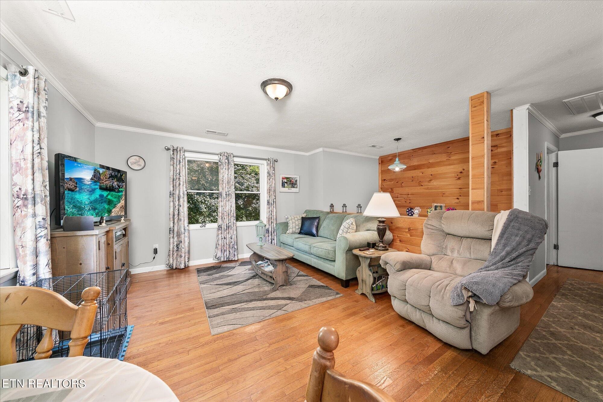 876 Shady Grove Road Lancing, TN 37770 - Photo 6 of 23 a living room with furniture large windows and a flat screen tv