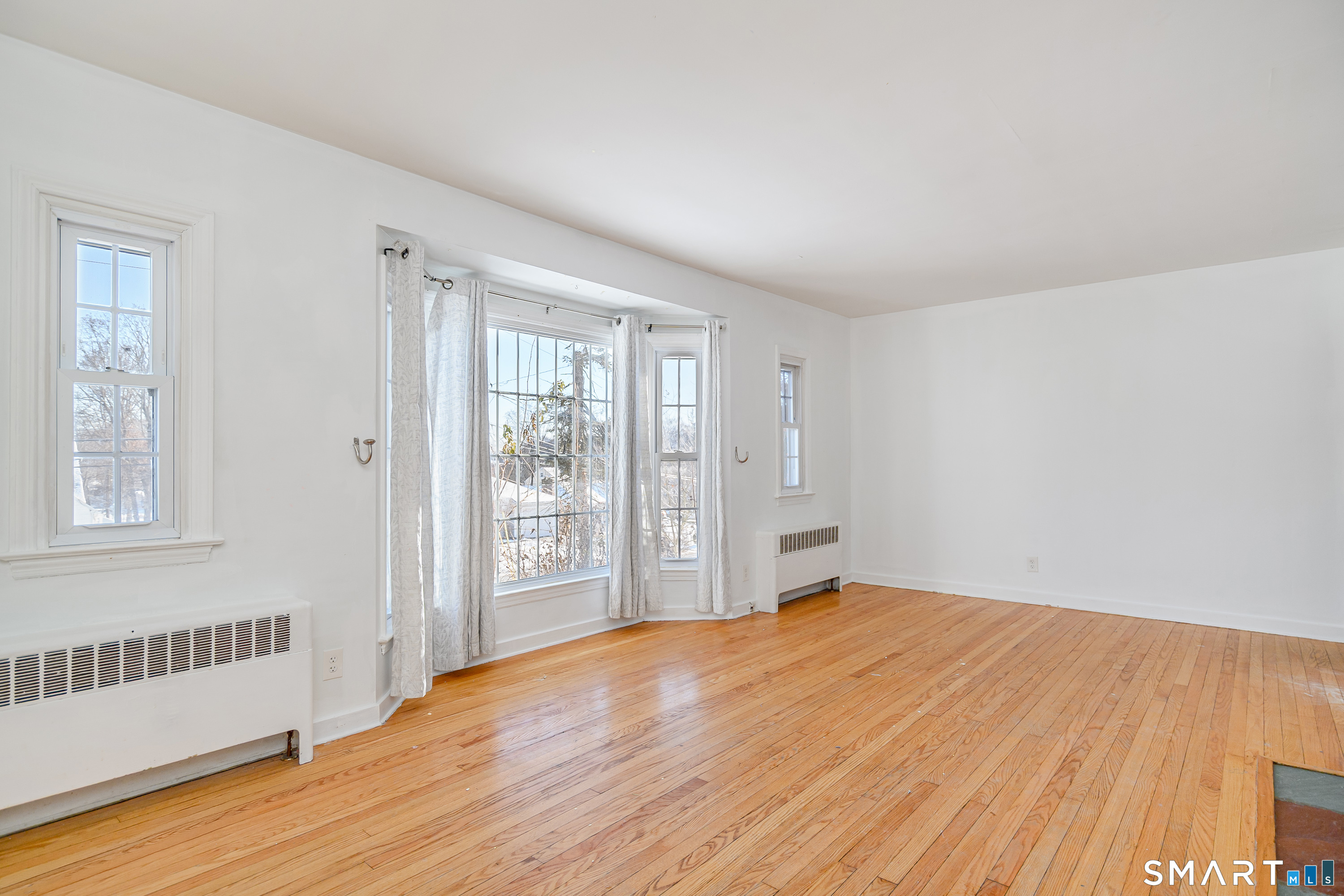 8 1st St Extension Danbury, CT 06810 - Photo 17 of 23 a view of an empty room with wooden floor and a window