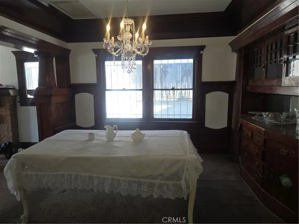 a bedroom with a large bed and a chandelier next to a window