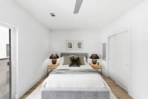 a bedroom with a bed a window and lamp