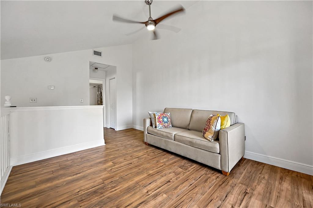 938 Augusta Boulevard, Unit D937 Naples, FL 34113 - Photo 11 of 27 a living room with furniture and a wooden floor