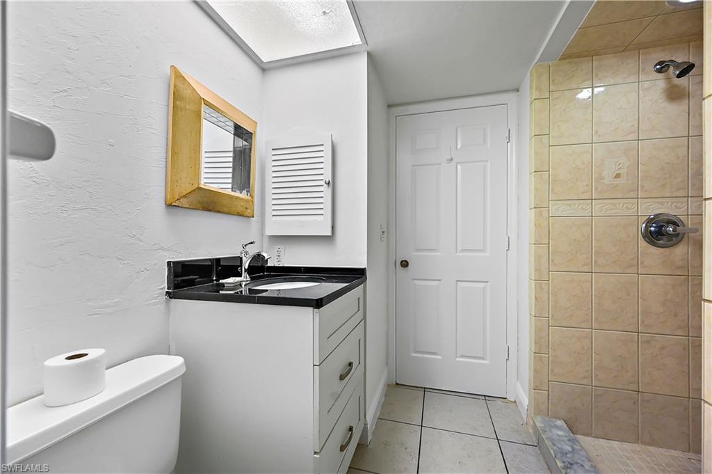 938 Augusta Boulevard, Unit D937 Naples, FL 34113 - Photo 19 of 27 a bathroom with a granite countertop sink a toilet and a mirror