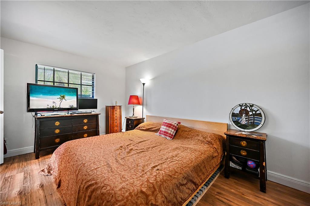 938 Augusta Boulevard, Unit D937 Naples, FL 34113 - Photo 20 of 27 a bedroom with a bed and a flat screen tv