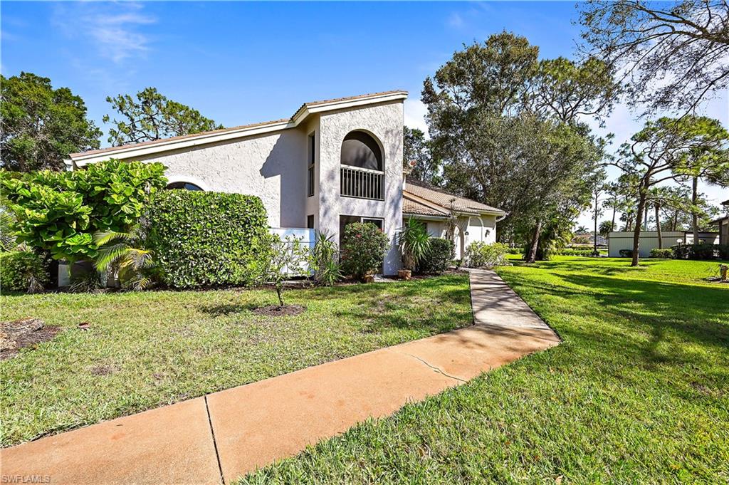 938 Augusta Boulevard, Unit D937 Naples, FL 34113 - Photo 2 of 27 a front view of a house with a yard